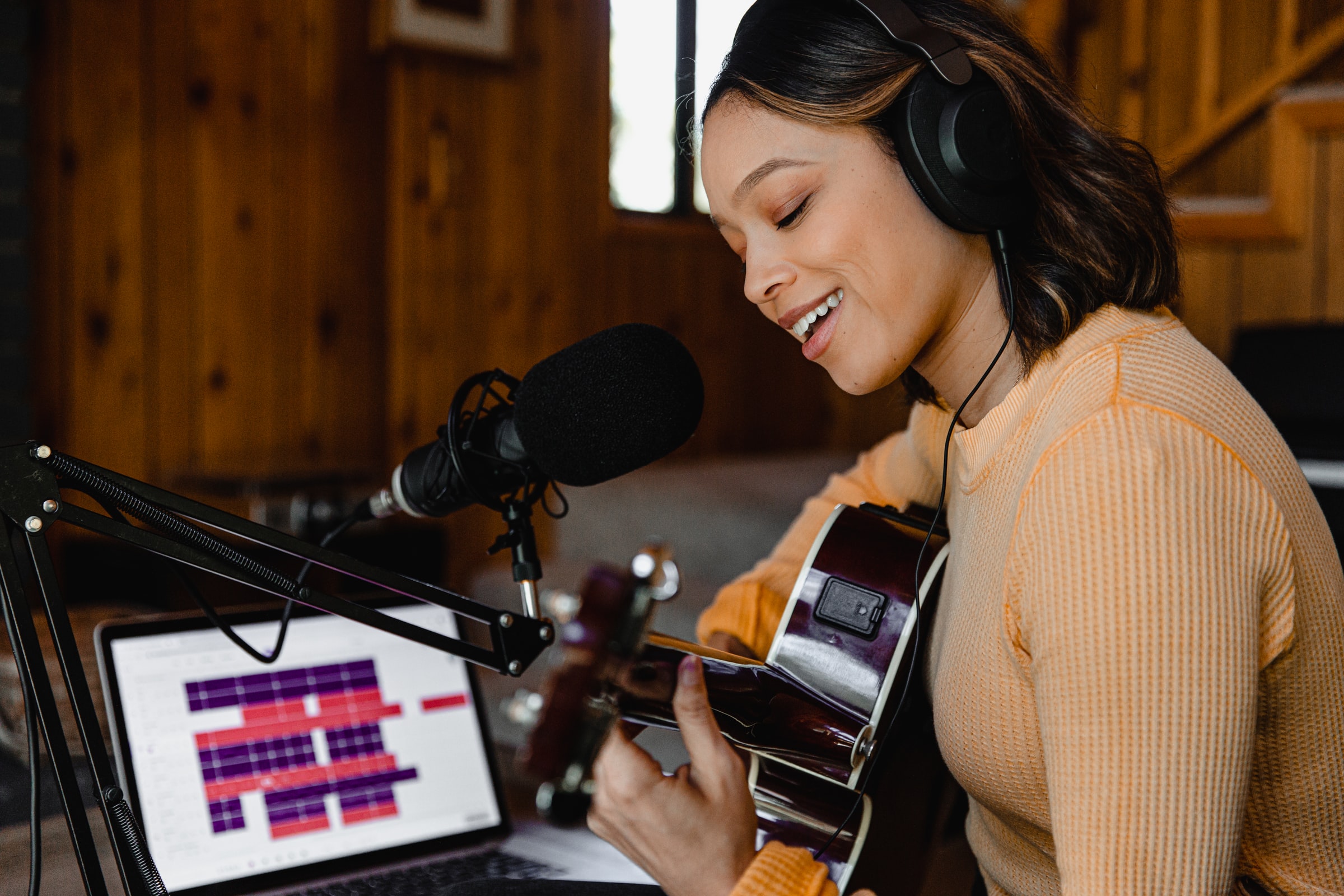 Lady playing guitar with headphone and microphone