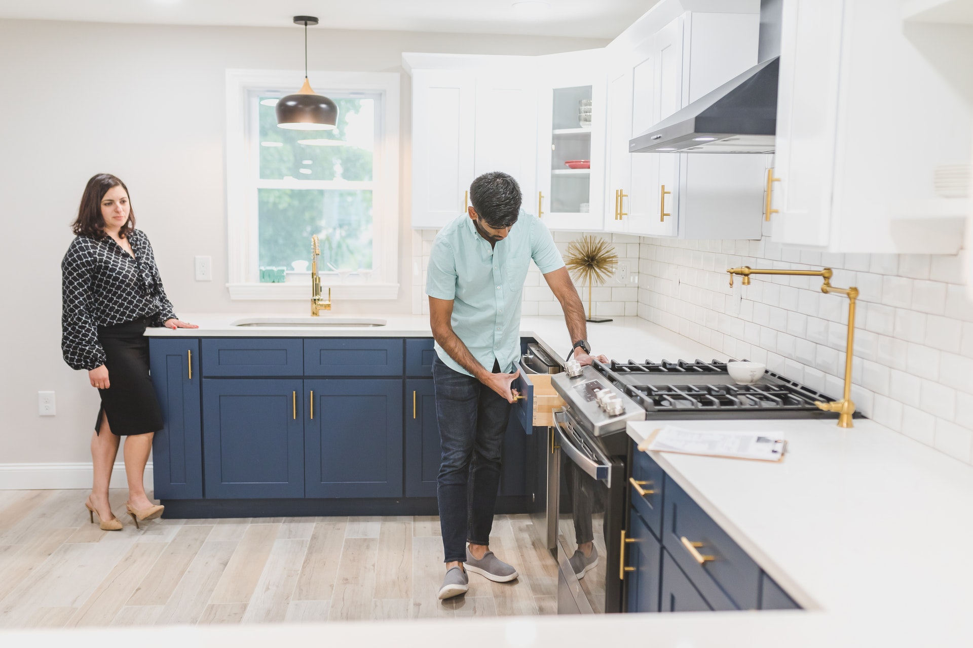 man and women inspecting kitchen cupboad